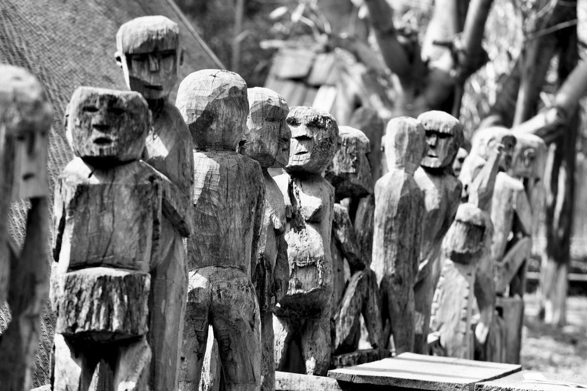 Statues en bois devant la maison funéraires des Hauts Plateaux du Centre