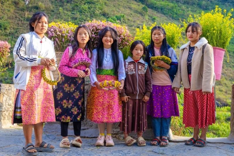 Des filles locales portant des paniers de fleurs (source: fr.nhandan.vn)