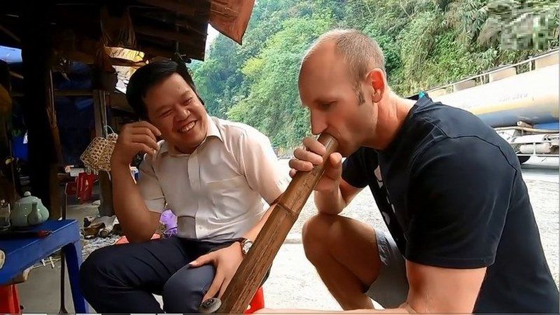 un voyageur essaye de fumer thuoc lao