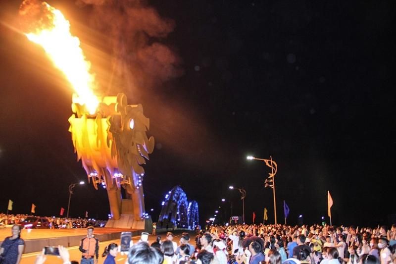 les touristes sont fascinés par le moment où le pont du dragon crache du feu. Source : vinwonders.com