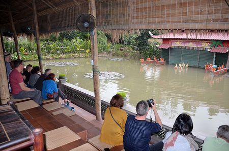 Les touristes regardent des marionnettes sur l'eau sur le site touristique de Don Son, dans le village de Yen Duc.