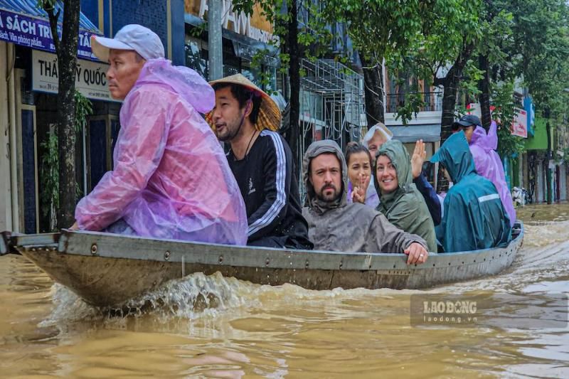 les eaux de crue ont encerclé la ville de huế, obligeant les touristes à monter sur des bateaux pour fuir les inondations
