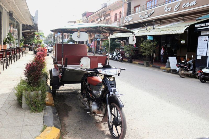 La imagen muestra un tuktuk en Kampot, situando Camboya en el mapa como un país donde la vida cotidiana y la cultura local forman parte del viaje.